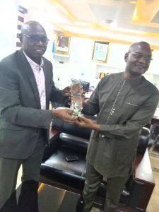 National Cordinator of Port Standing Task Team (PSTT) Comrade Moses Olayemi Fadipe (left) presenting an award bestowed on the PSTT by Council of Maritime Truckers Union's and Associations (COMTUA) to the Executive Secretary, Hon Emmanuel Jime