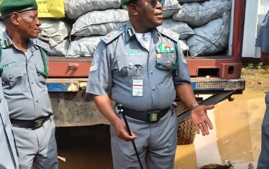 Acting Controller of FOU Zone'A'of customs, Hussein Kehinde Ejibunu displaying seized containers of rice