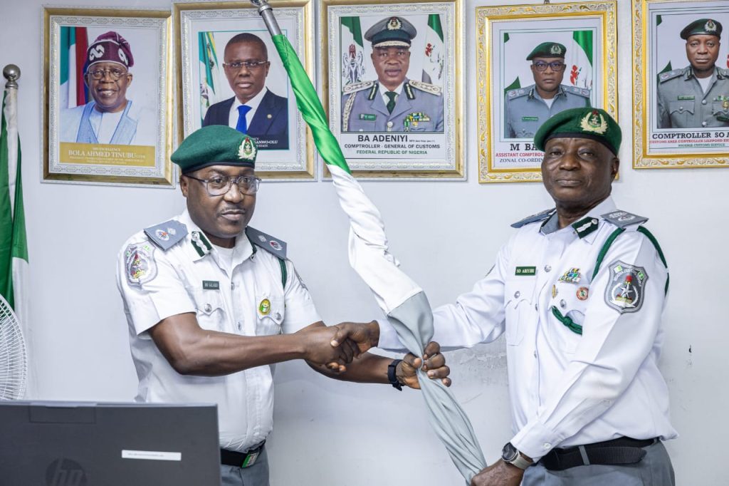 Retired Compt Ariyibi (right) handing over Lilypond Export Command to DC Salako