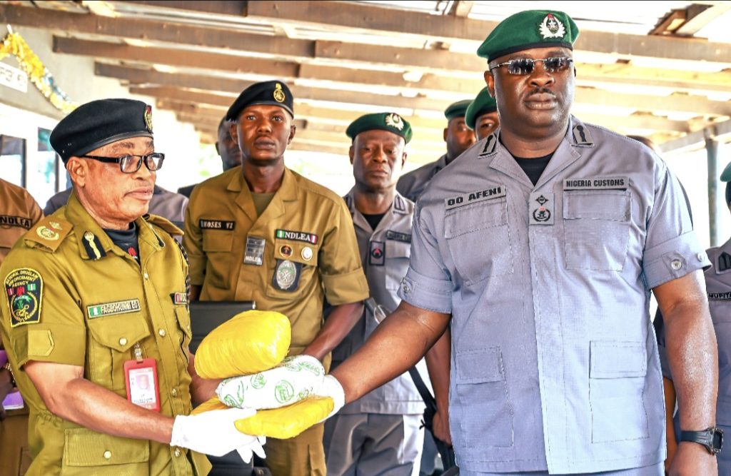 Deputy Comptroller Olukayode Oladapo Afeni (right) Customs Controller, Idiroko Border Command hands over seized cannabis to the National Drug Law Enforcement Agency (NDLEA)